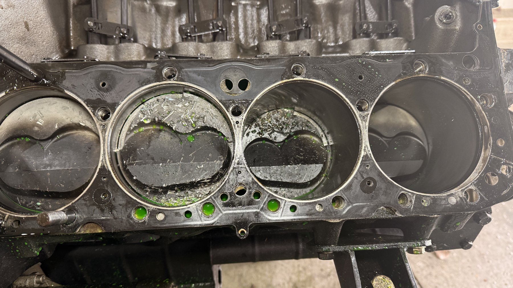 The short block, opened up — bores scored, coolant residue, the whole story
